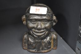 An early 20th Century cast metal money bank, in the form of a Jolly man, 11.5cm tall