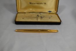 A boxed Waterman Converter Fill fountain pen in gold chaised pattern having 14ct nib. Very good