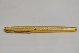 A Parker 75 Grain D'ore cartridge converter fountain pen in gold plate with engine turned pattern.