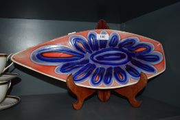 A mid century Poole Pottery serving platter, having red ground with abstract blue floral pattern.