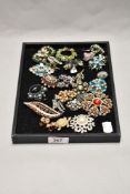 A tray of miscellaneous costume jewellery brooches and clip on earrings, to include a gold