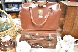 A vintage brown leather doctor's bag together with two other brown leather suitcases