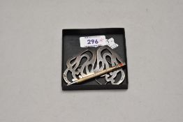 A silver nurses buckle of moulded scroll form and a retracting silver bridge pencil
