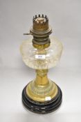 An early 20th Century Young's brass oil lamp, having a cut glass reservoir, and on a stepped