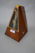A vintage German metronome having wood case.