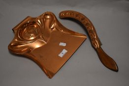 An Art Nouveau copper crumb tray and copper clad brush, with embossed decoration, registration