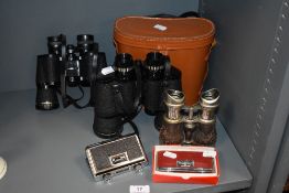 Three sets of binoculars including early 20th century set, Tasco and Proloisirs and two sets of