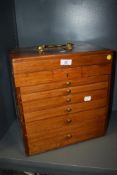 An early 20th century lockable mahogany collectors chest, having top tray over six drawers, some