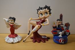 Three Betty Boop figurines including Betty in Red dress, Betty in red glittered gown and Betty on