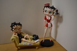 Two Betty Boop figurines, Betty on cream sofa and Betty diner waitress.