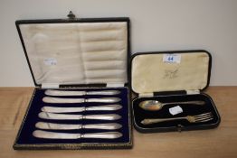 A cased set of six silver plated butter knives, with silver hallmarked handles, and a cased