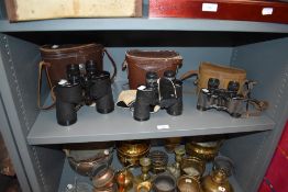 Three pairs of binoculars with cases, including Swift, Canon and Laberte.