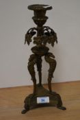 A 19th/20th Century French brass candlestick raised on tripod base, 29.5cm tall