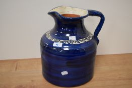A 20th Century blue glazed jug or vase with slipware design, measuring 30cm tall