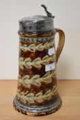 A 19th/20th Century Doulton Lambeth stoneware lidded stein, the white metal engraved lid above a