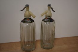 Two mid-20th Century Schweppes soda siphons with etched design, measuring 30cm tall