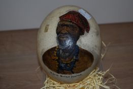 An ostrich egg, hand painted with a portrait of a Zulu Witch Doctor, measuring 18cm tall