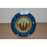 A 1930s Clarice Cliff Fantasque design ashtray, blue glazed border, and having a diameter of 12cm