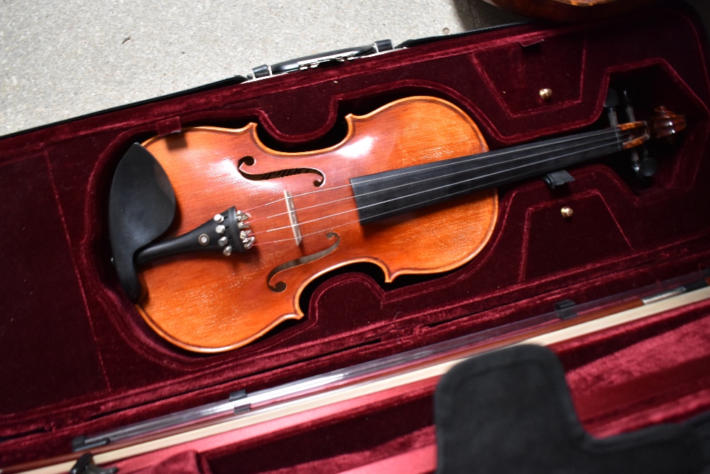 A modern violin having one piece 14inch back , labelled Bellolino, with plush fitted case and bow