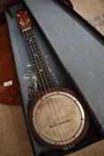 A vintage banjo ukulele with floral decoration to headstock