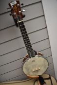 A modern banjo ukulele , headstock marked with treble clef, in padded Gretsch case