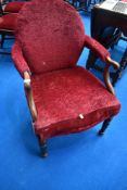 A Victorian mahogany easy chair having later burgundy upholstery and scroll arms