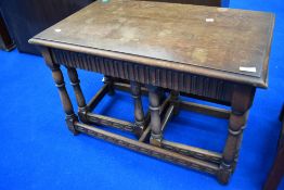 A vintage Priory style nest of one large and two smaller occasional tables