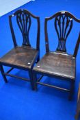 Two Georgian oak solid seat dining chairs