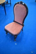 A Victorian mahogany nursing chair having knurl frame and later pink upholstery