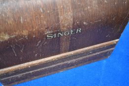A vintage Singer sewing machine in wooden dome top case