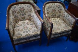A pair of Edwardian mahogany tub chairs having later floral upholstery
