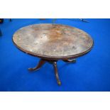 A Victorian oval table having quarter veneered walnut top on turned column, quadrupl shaped legs and