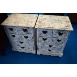 A pair of modern shabby chic style bedside cabinets with heart motifs to drawer