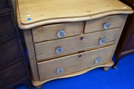 A Victroian stripped pine chest of two over two drawers, having shaped top, with glass handles to
