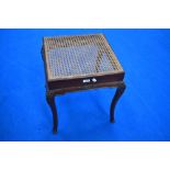 A cane seated mahogany dressing table stool in the classical style