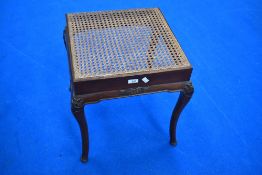 A cane seated mahogany dressing table stool in the classical style