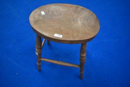 A traditional solid seat stool having turned frame