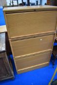 A vintage office cabinet having triple section with tambour doors