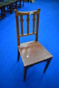 An Arts and Crafts style solid seat hall or dining chair in golden oak