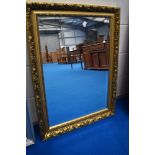 A modern overmantel or wall mirror having gilt effect frame