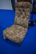A Victorian nursing or boudoir chair having turned mahogany legs and stuffed seat and back with