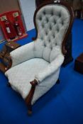 A Victorian spoonback chair having scroll arms and later light green button back upholstery