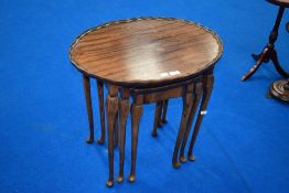 A vintage reproduction period style nest of three oval occasional tables