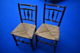 A pair of 19th Century spindle back kitchen chairs having rush seats