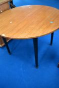 A vintage circular extending dining table, possibly McIntosh having ebonised legs, diameter approx