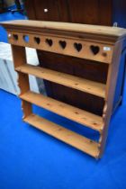 A traditional pine delft rack with heart motif to frieze