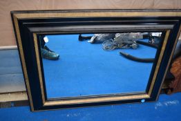 A vintage ebonised and gilt frame wall mirror