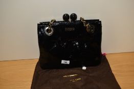 A black patent leather style Kate Spade handbag, with dust cover.