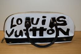 A ladies designer handbag, with a stitched Louis Vuitton label to the interior