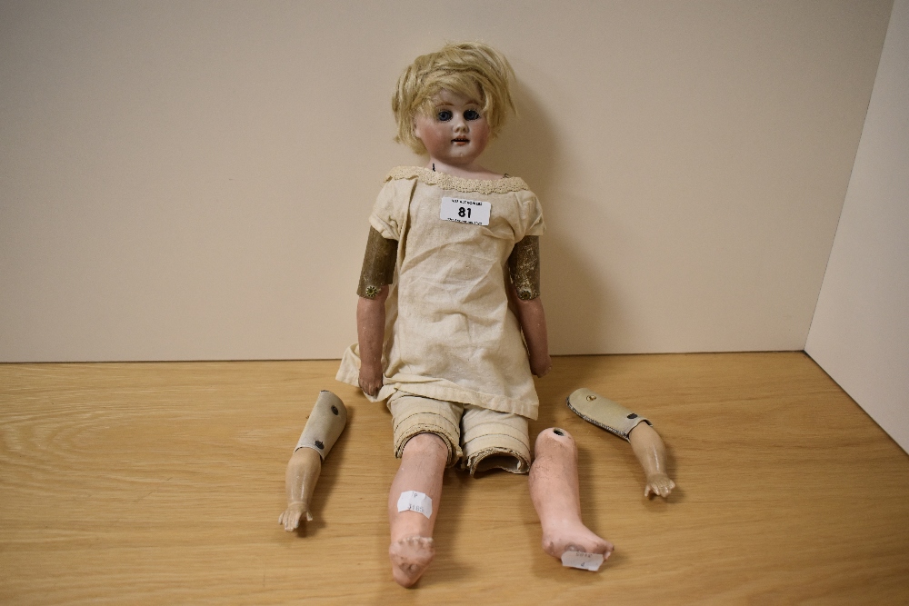 A late 19th/early 20th Century bisque shoulder head doll, having blue sleep eyes, a kid leather
